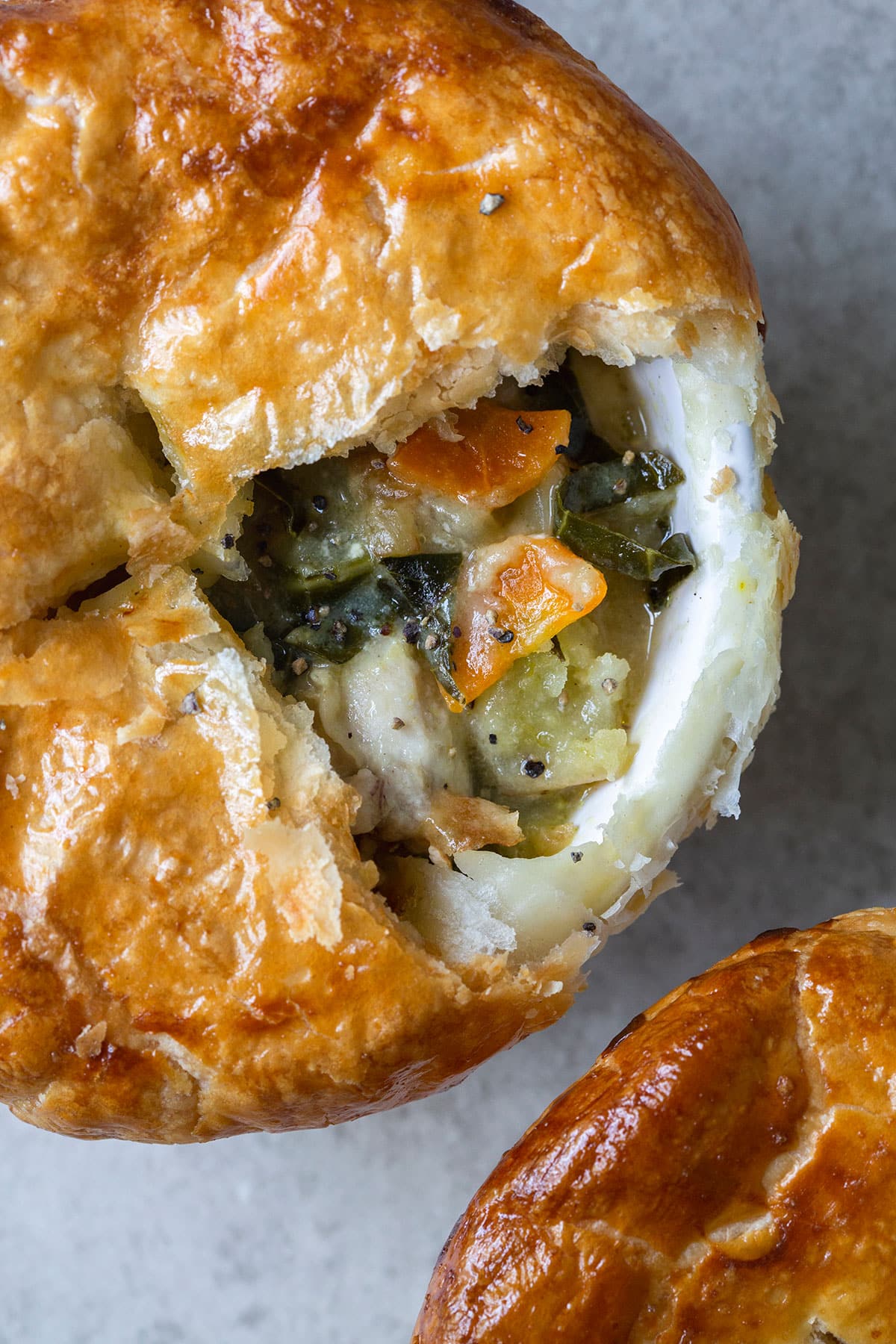 A top down shot of potpie revealing its inside filling consisting of chicken, carrots, and other vegetables. 