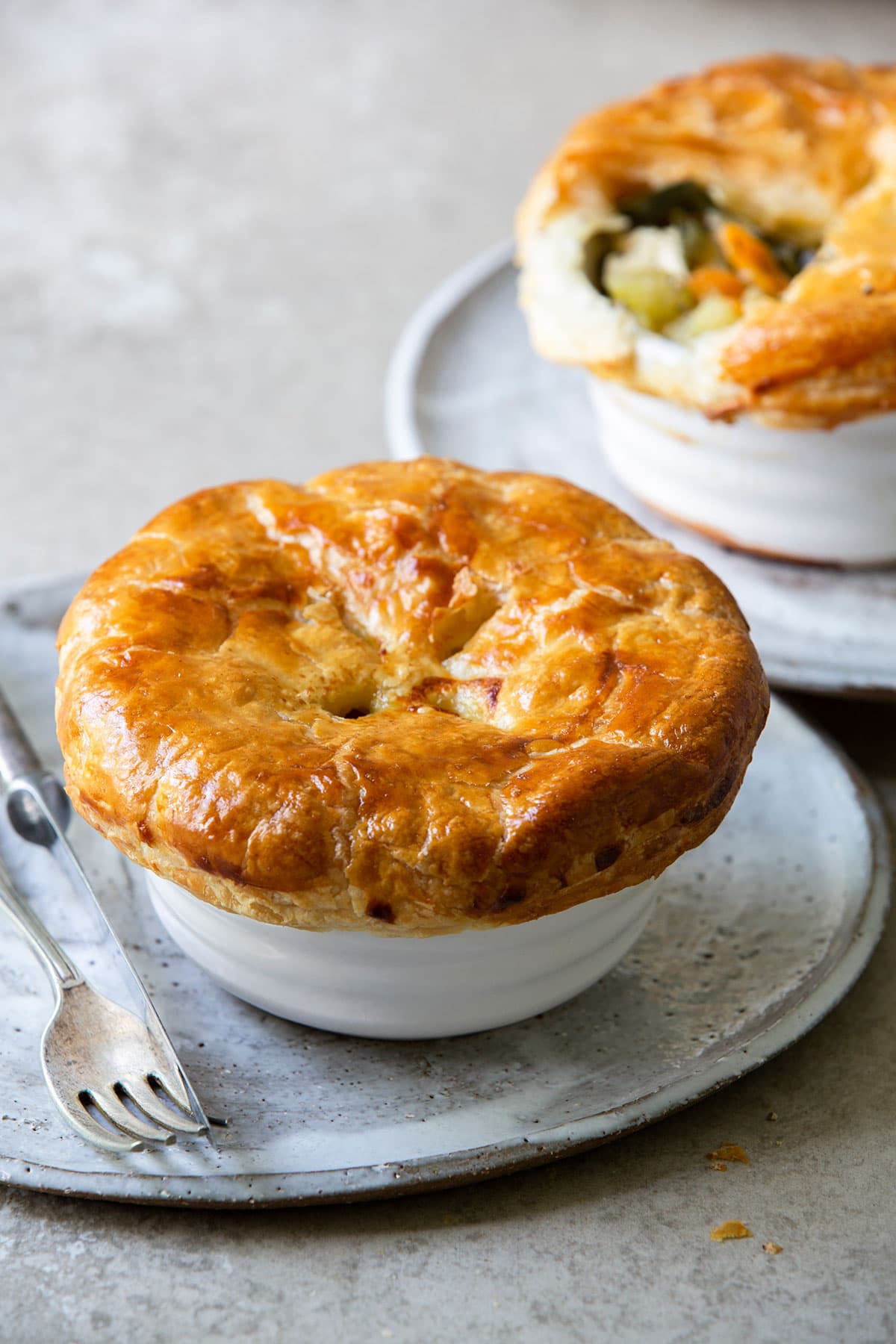 Easy and delicious chicken potpie served on top of a plate with knife and fork at the side. 