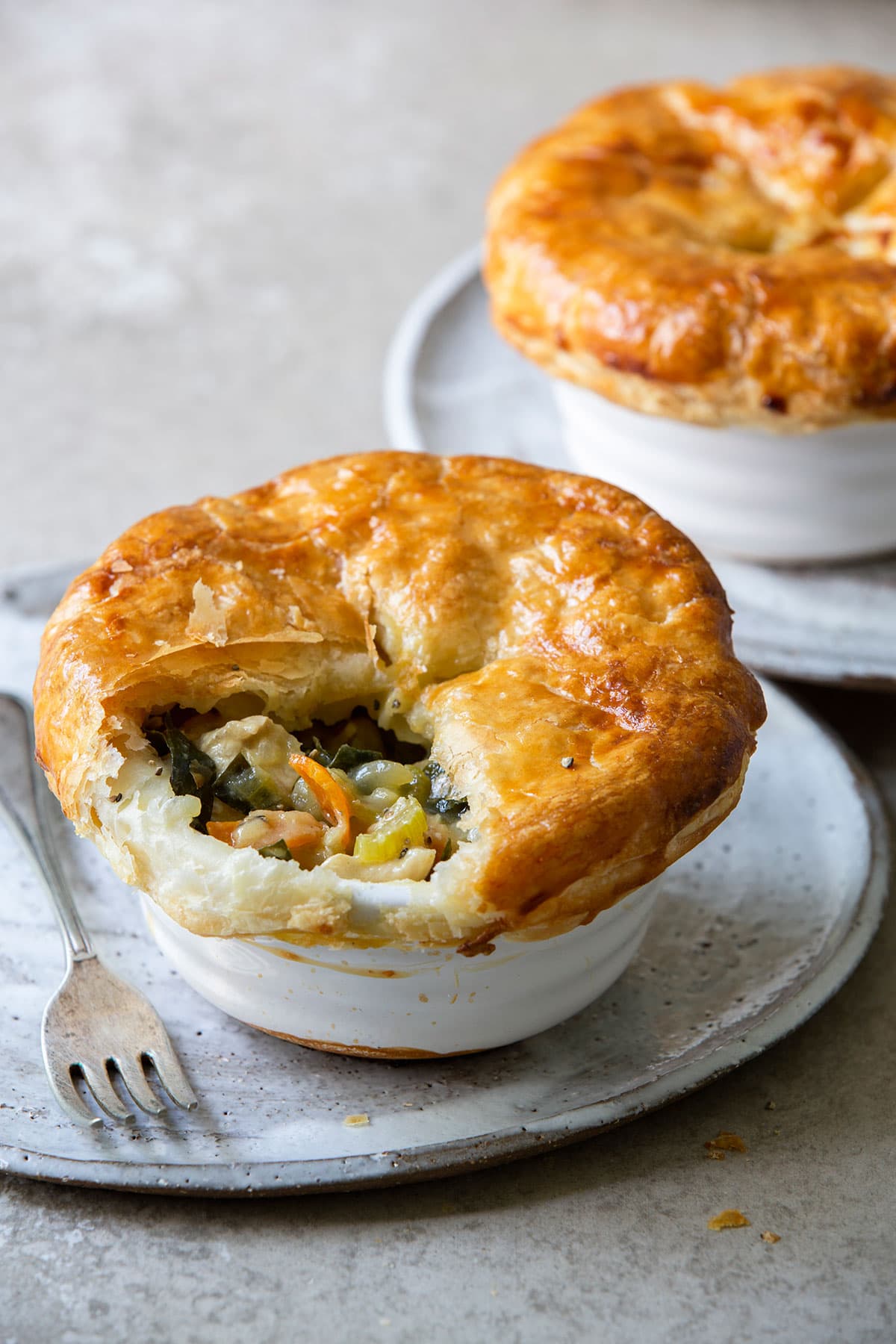 A potpie half opened showcasing a golden-brown crust and a rich, savory filling. 