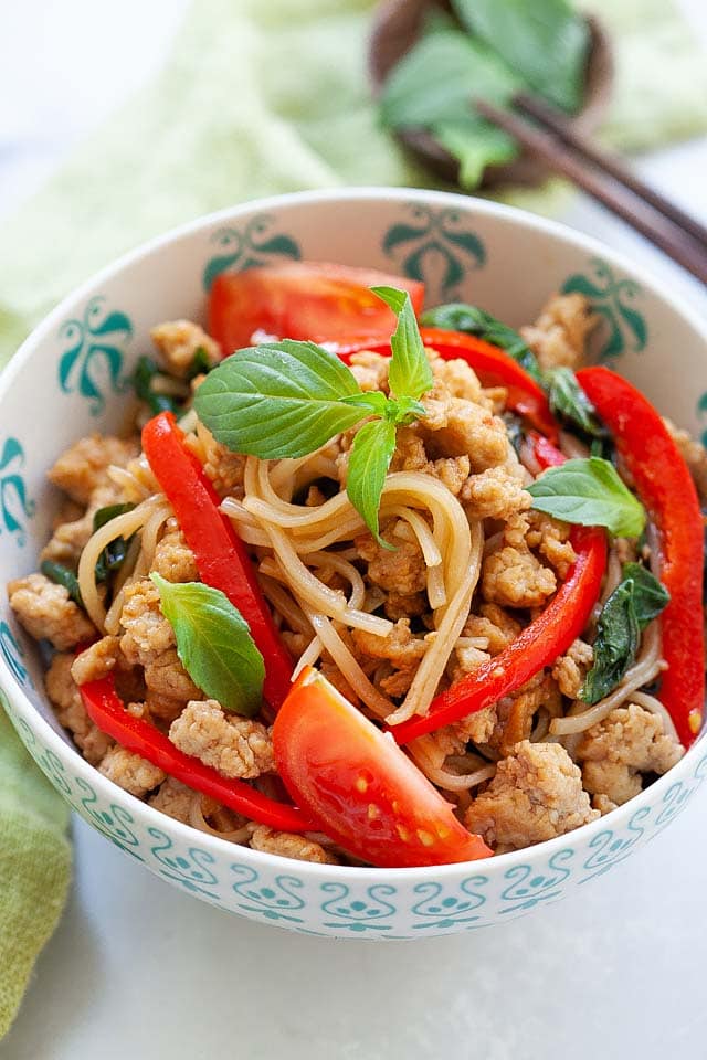 Drunken noodles in a bowl, ready to serve with a pair of chopsticks.