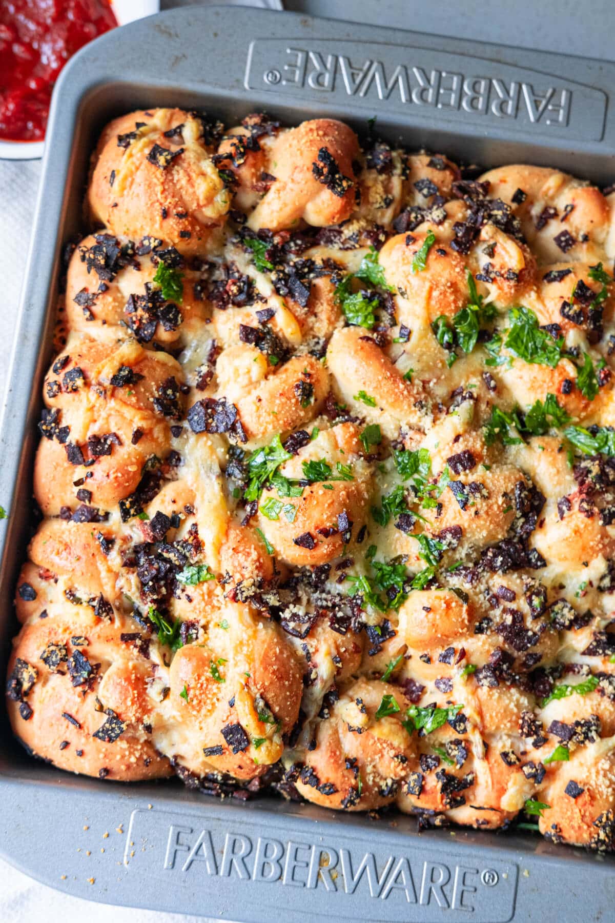 Easy pull-apart pepperoni garlic knots in a baking pan with crispy pepperoni on top.