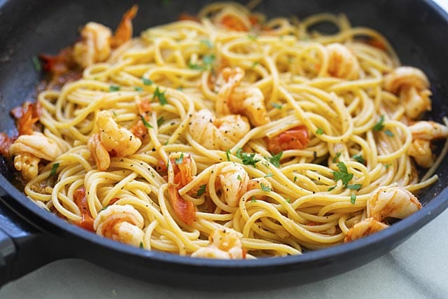 Shrimp pasta cooking in skillet.