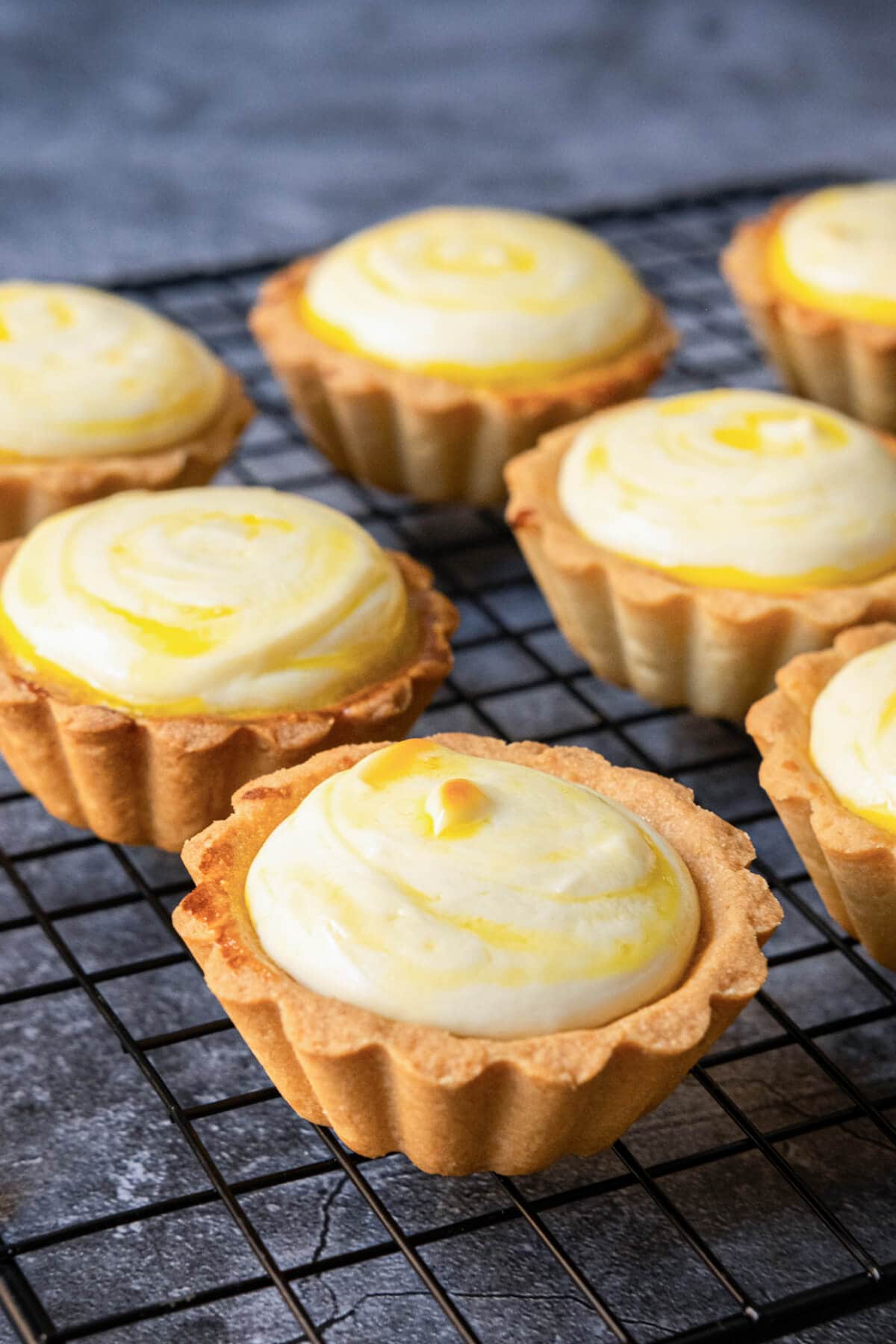 An appetizing image of tarts, with golden baked crust and a luscious yellow cheesy filling. 