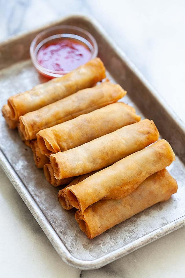 Lumpia or Filipino fried spring rolls on a plate with lumpia sauce, ready to be served.