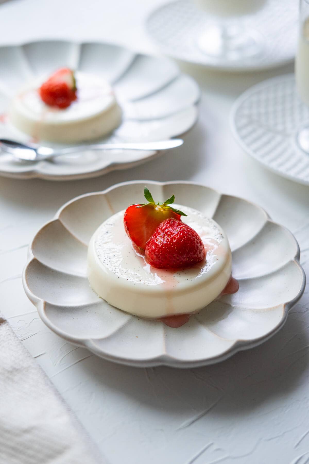 Strawberry panna cotta served with  syrup on top. 