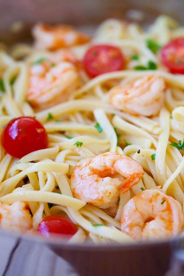 A plateful of shrimp scampi served with linguine pasta and cherry tomatoes.