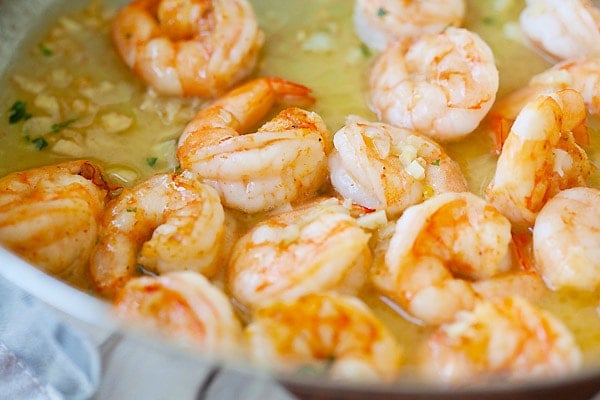 Shrimp in garlicky and buttery shrimp scampi sauce in a skillet.
