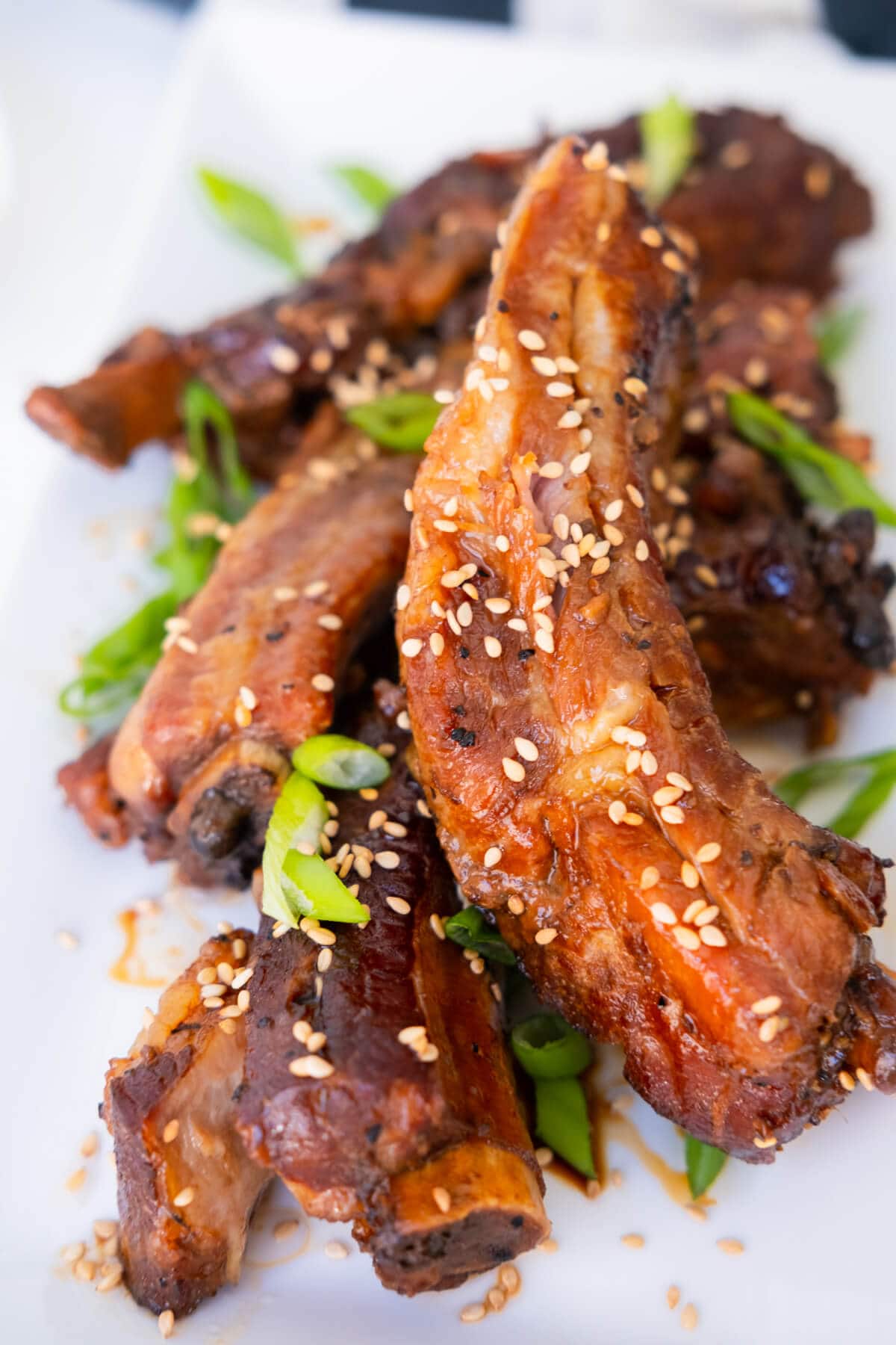 Tender and juicy ribs covered in teriyaki sauce served on a white plate. 