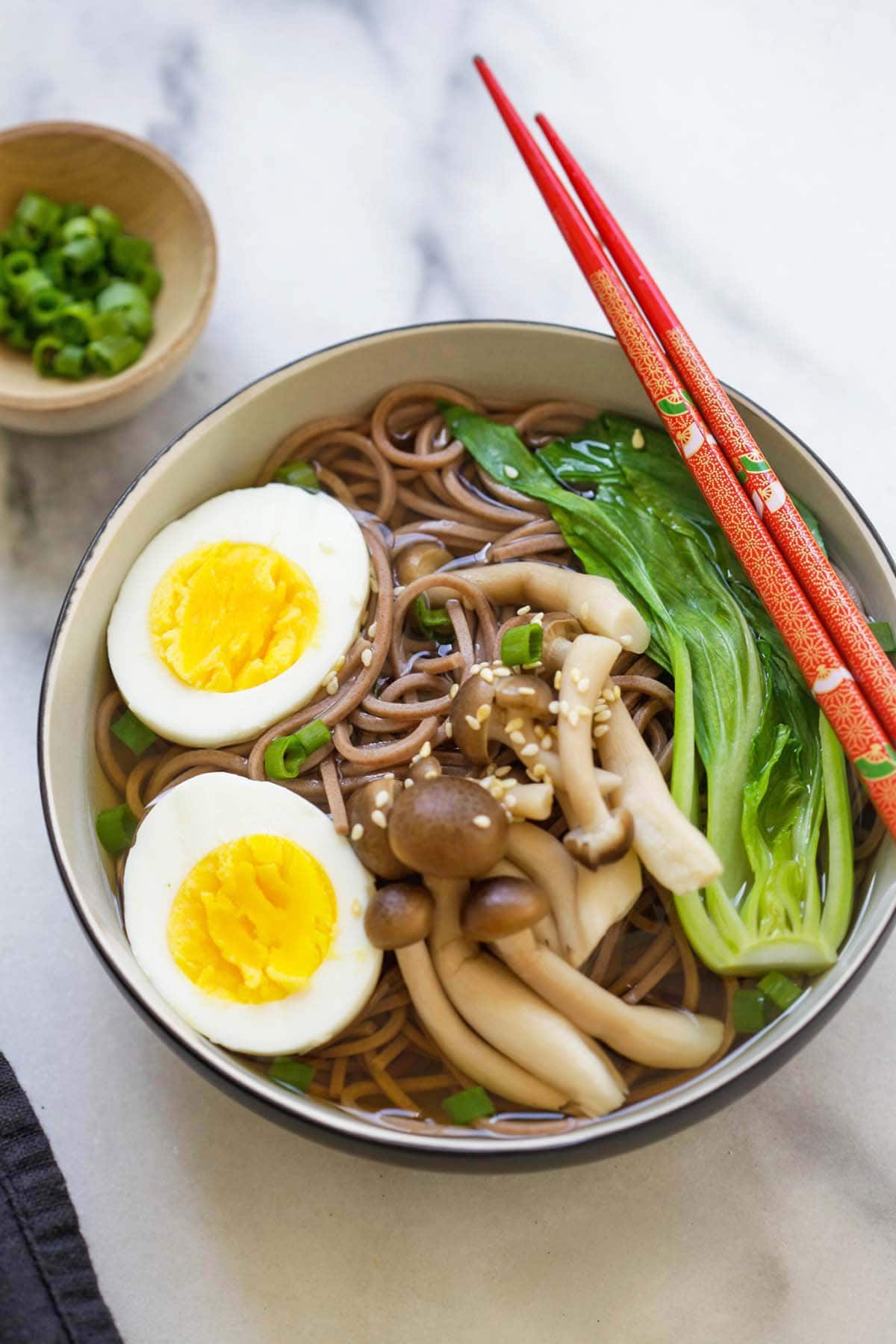 Healthy Japanese Soba noodle soup in a bowl with chopsticks.