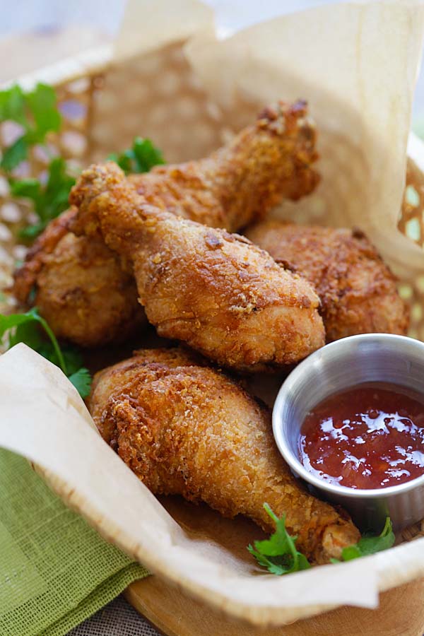 Easy and quick Thai fried chicken marinated with cilantro, garlic and Asian seasonings in a basket with a side of Thai sweet chili dipping sauce.