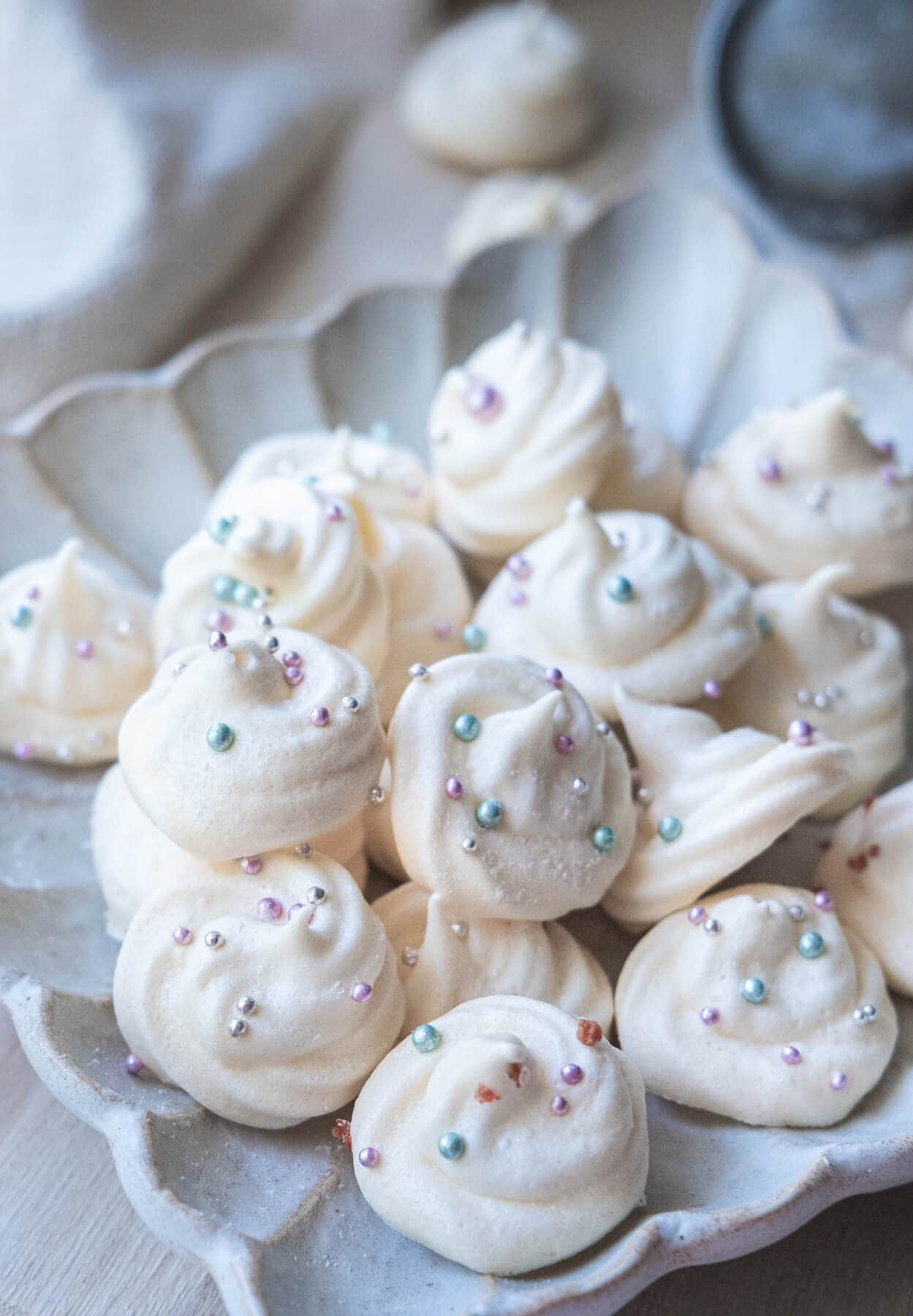 Vanilla meringue cookies topped with sprinkles. 